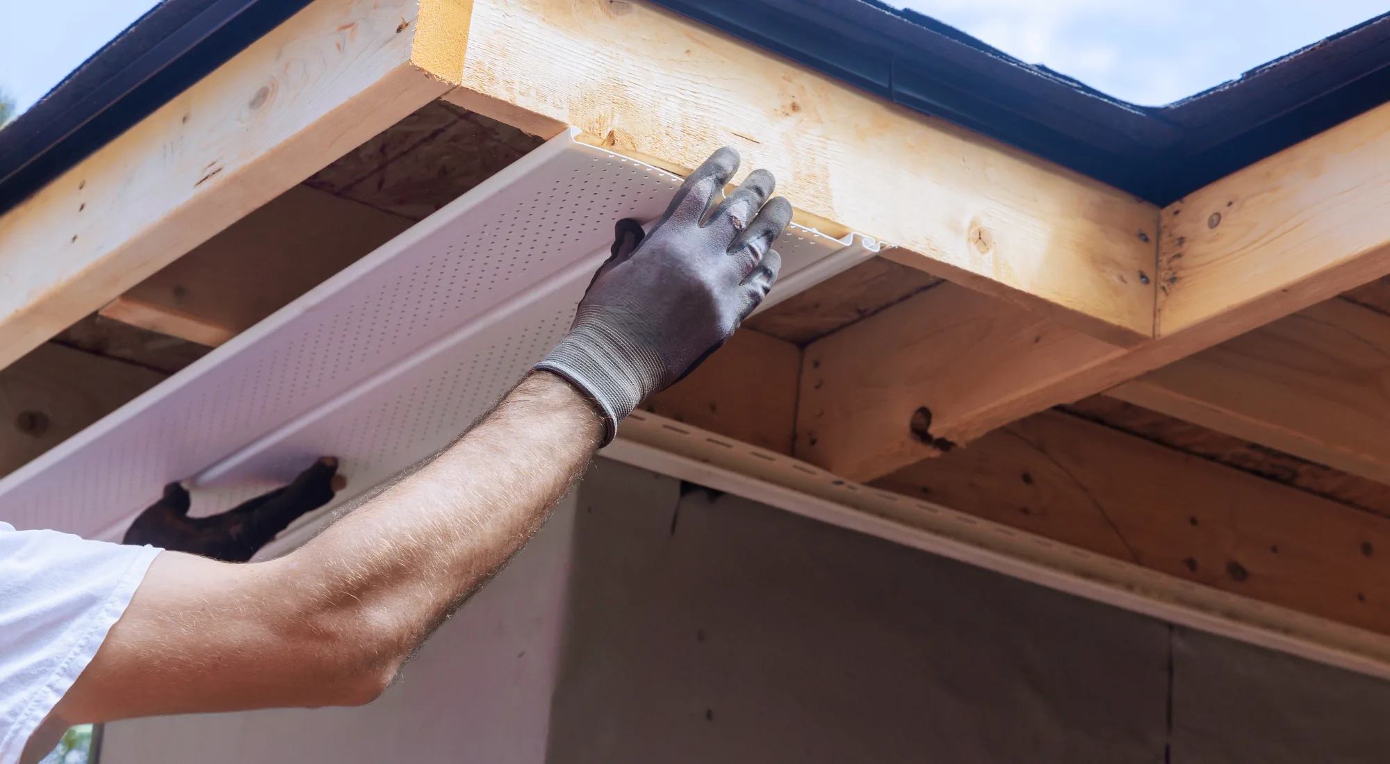 Damaged soffit panel on a residential roof being repaired to prevent pest entry and moisture damage.